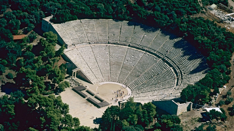 Theater von Epidauros Ein riesiges Amphitheater, umgeben von Bäumen.
