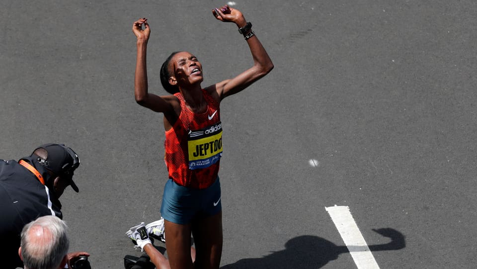 Die Kenianerin Rito Jeptoo auf den Knien mit erhobenen Händen nach dem Sieg beim Boston-Marathon 2014 