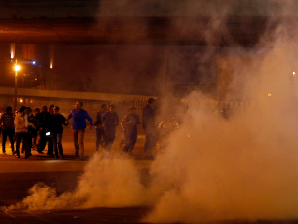 Demonstranten flüchten vor einer Tränengas-Wolke.