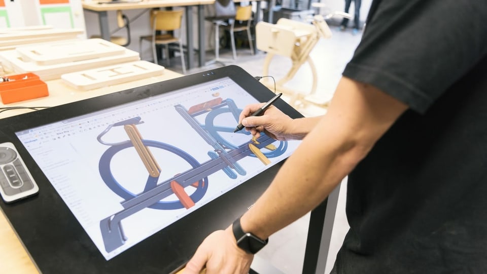 Ein Student arbeitet auf einem grafischen Tablet an einem Design.