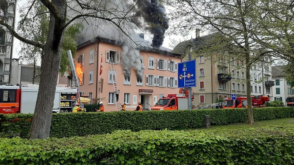Rauch steigt aus dem Gebäude, die Feuerwehr ist im Einsatz. 
