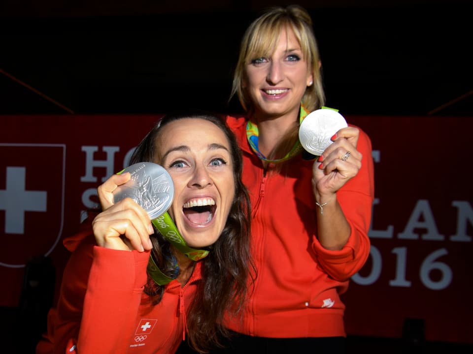 Martina Hingis und Timea Bacsinszky strecken ihre Silbermedaillen der Kamera entgegen.