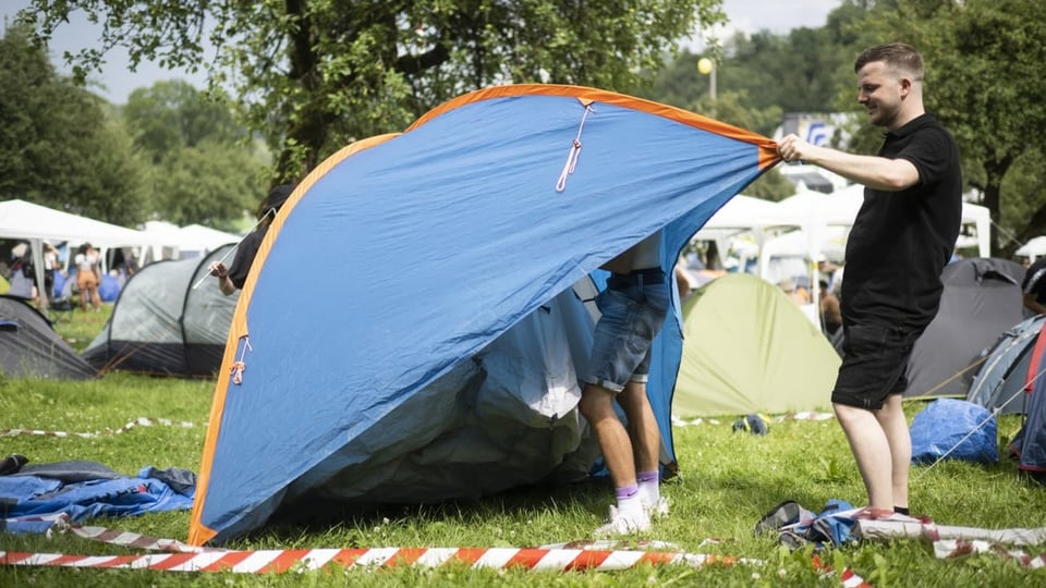 Zwei Männer bauen ein Zelt auf