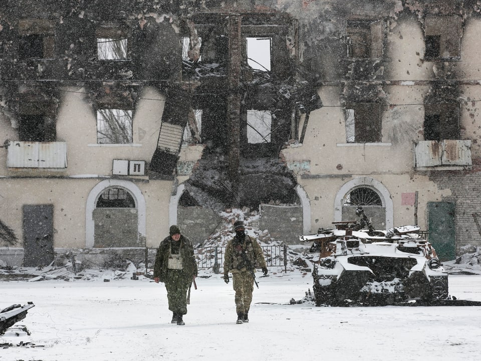 Soldaten vor einem ausgebrannten Haus