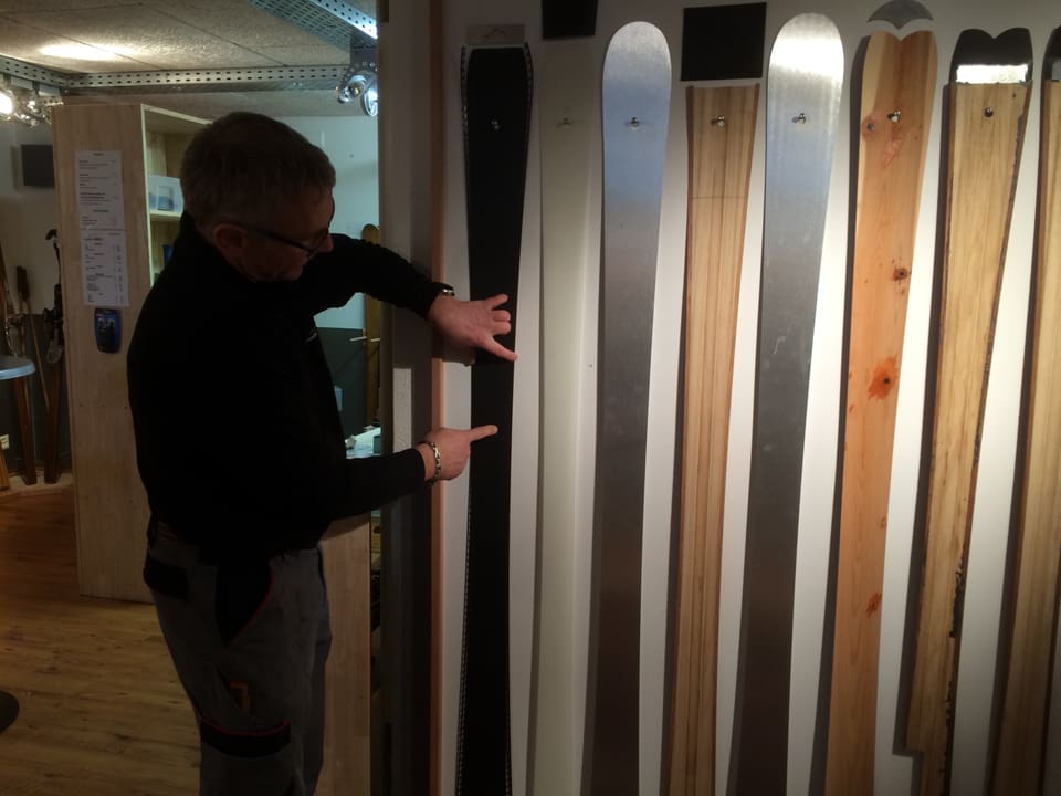 René Unternährer zeigt auf verschiedene Elemente, die dann zu einem Ski zusammengepresst werden. 