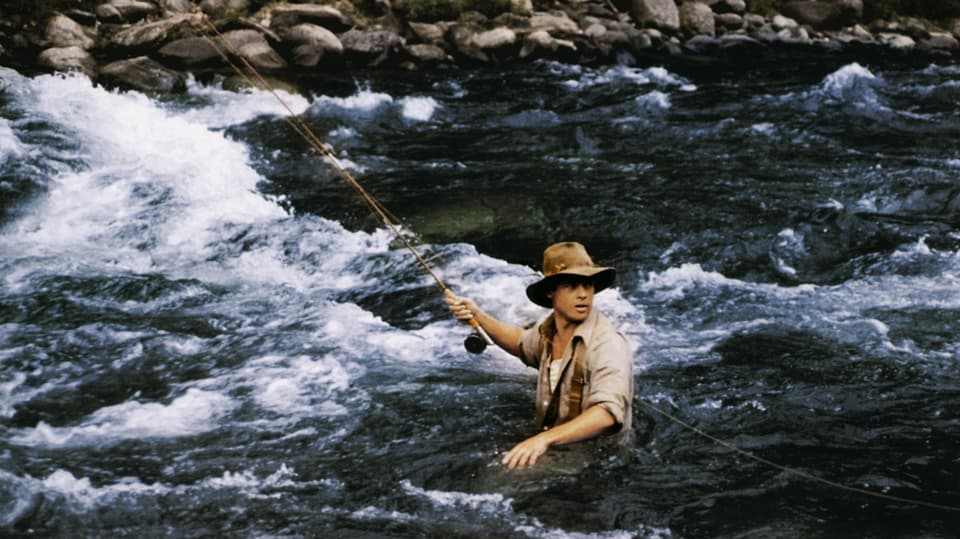Junger Mann beim Fliegenfischen in einem Fluss. 