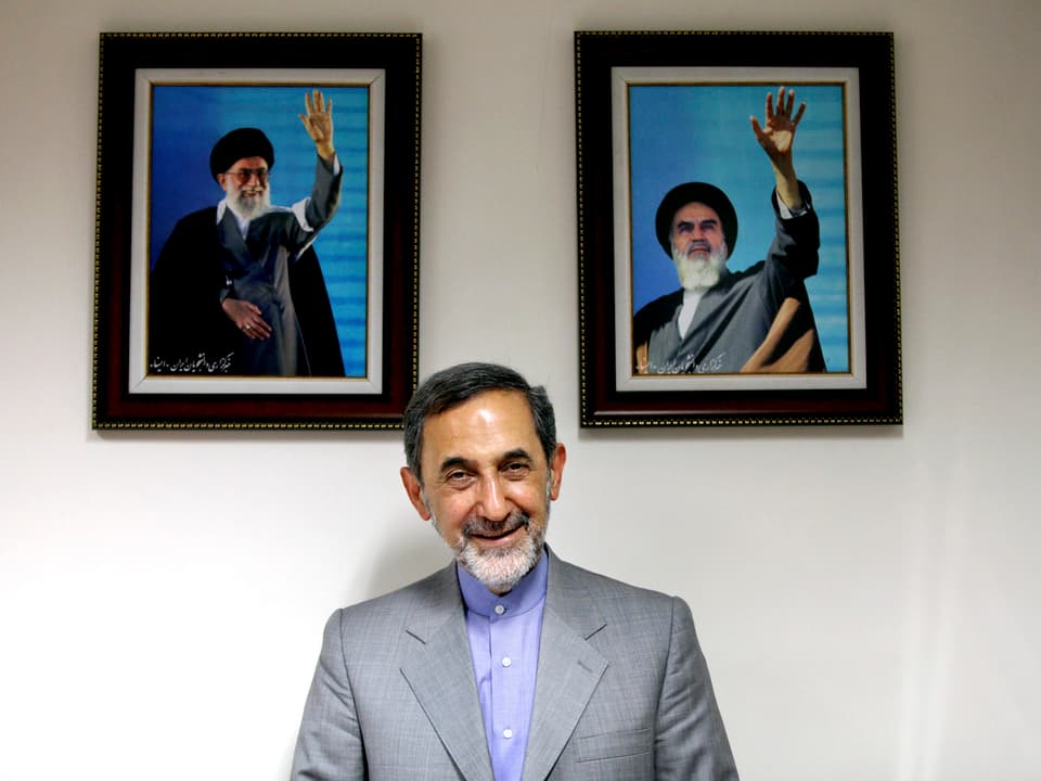 Velayati vor Bildern der Revolutionsführer Chamenei und Chomeini. 