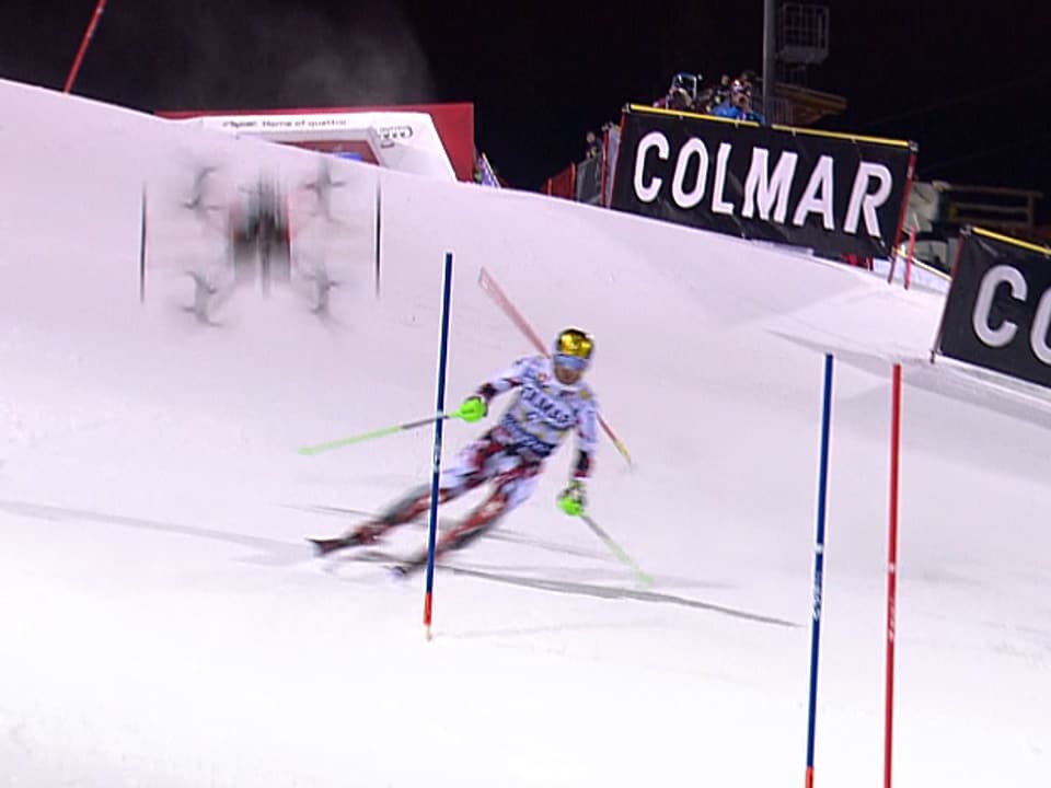 Die Kamera-Drohne stürzt hinter dem Skirennfahrer auf die Piste und zersplittert.