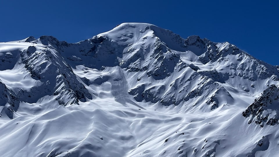 Verschneite Berggipfel unter blauem Himmel
