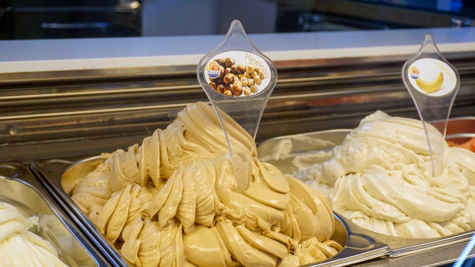 Verschiedene Eiscreme-Sorten in einer Eisdiele mit Fokus auf Nusseis.