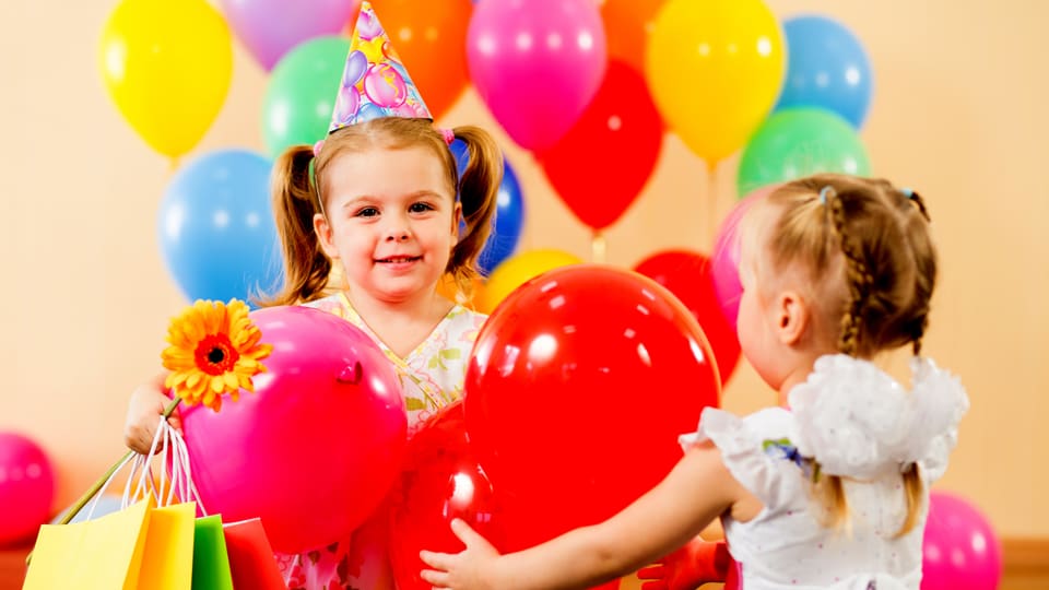 Kindergeburtstag mit zwei Màdchen und bunten Ballons.