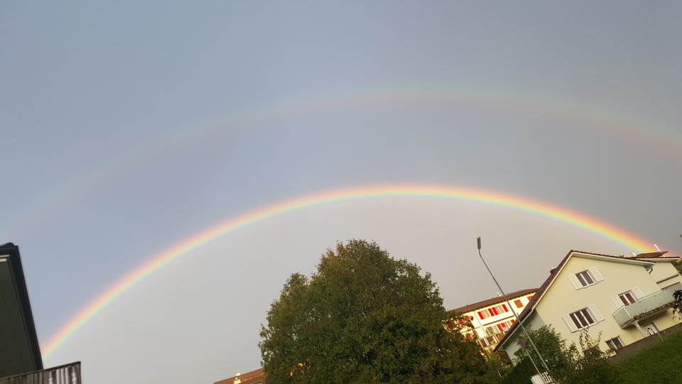 Doppelter Regenbogen über den Häusern.