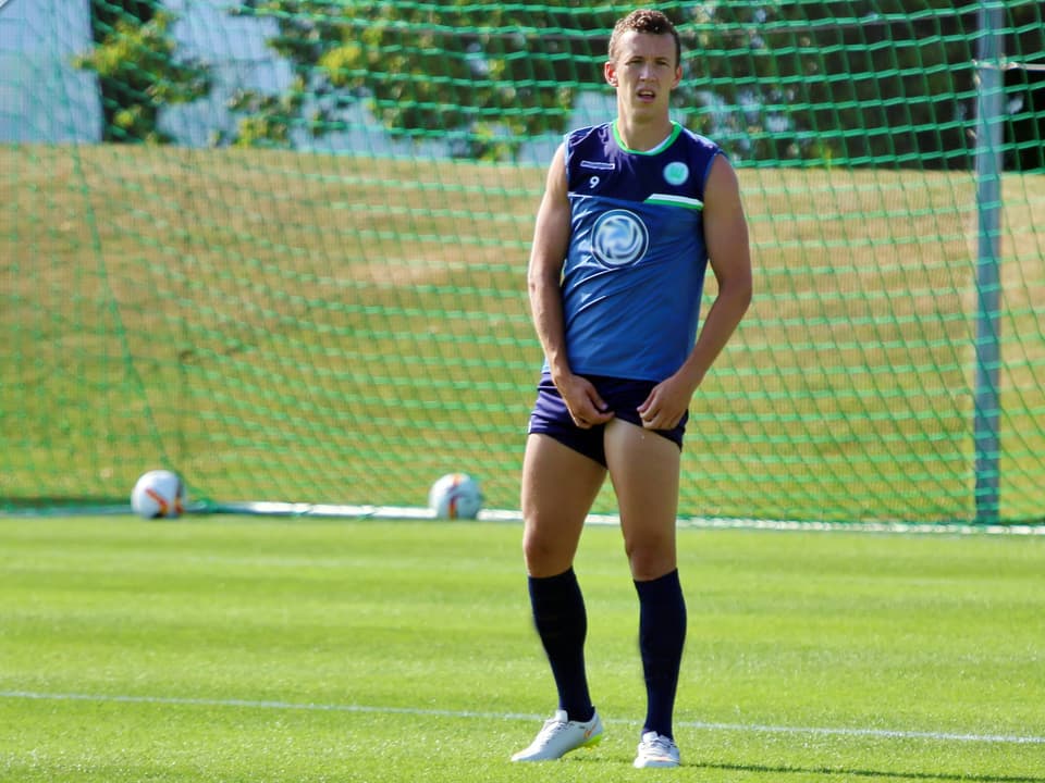 Football player standing on grass field.