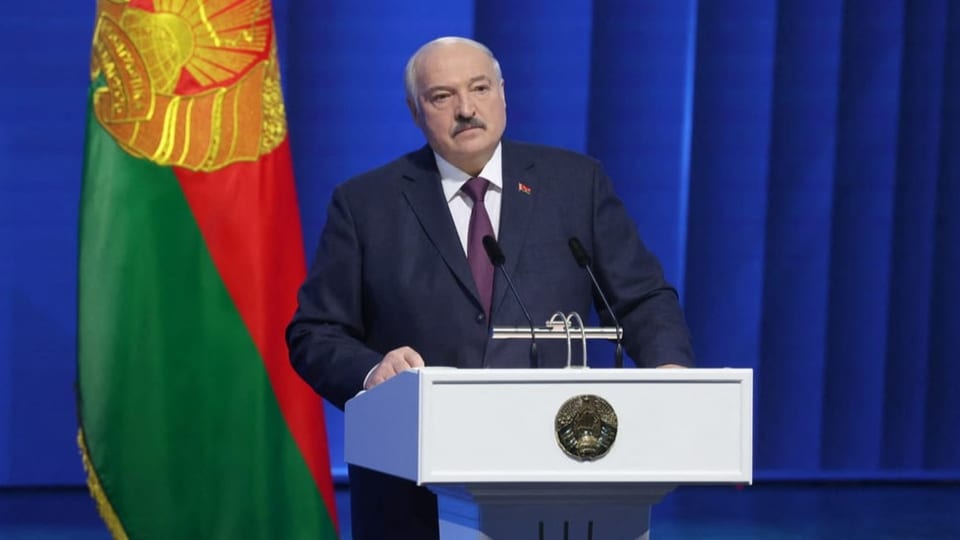 Lukaschenko am Rednerpult vor einer belarussischen Flagge.