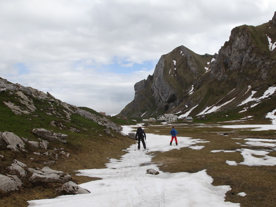 Schmales Schneeband mit zwei Skifahrern in felsiger Landschaft