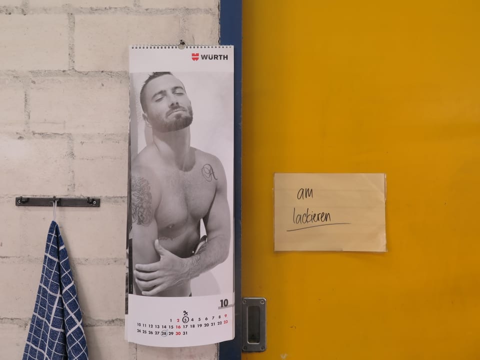 Weisse Wand, gelbe Tür, Kalender mit halbnacktem Mann.