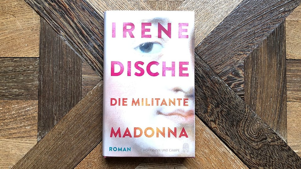 «Die militante Madonna» von Irene Dische liegt auf einem antiken Parkett.