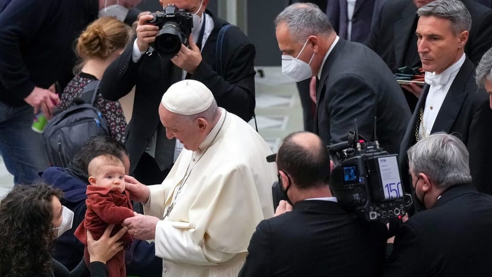 Papst segnet Kind.