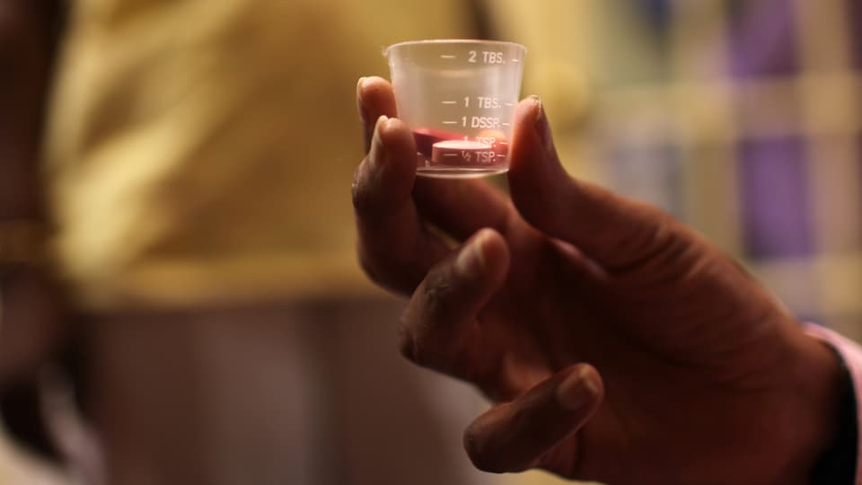 Ein Arzt gibt einem Patienten seine Aids-Medikamente.
