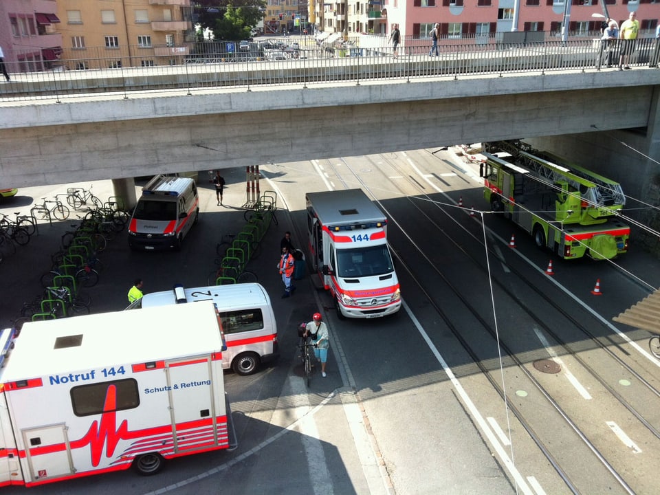 Am bahnhof Oerlikon stehen Ambulanz-Fahrezuge und Feuerwehr Autos. 