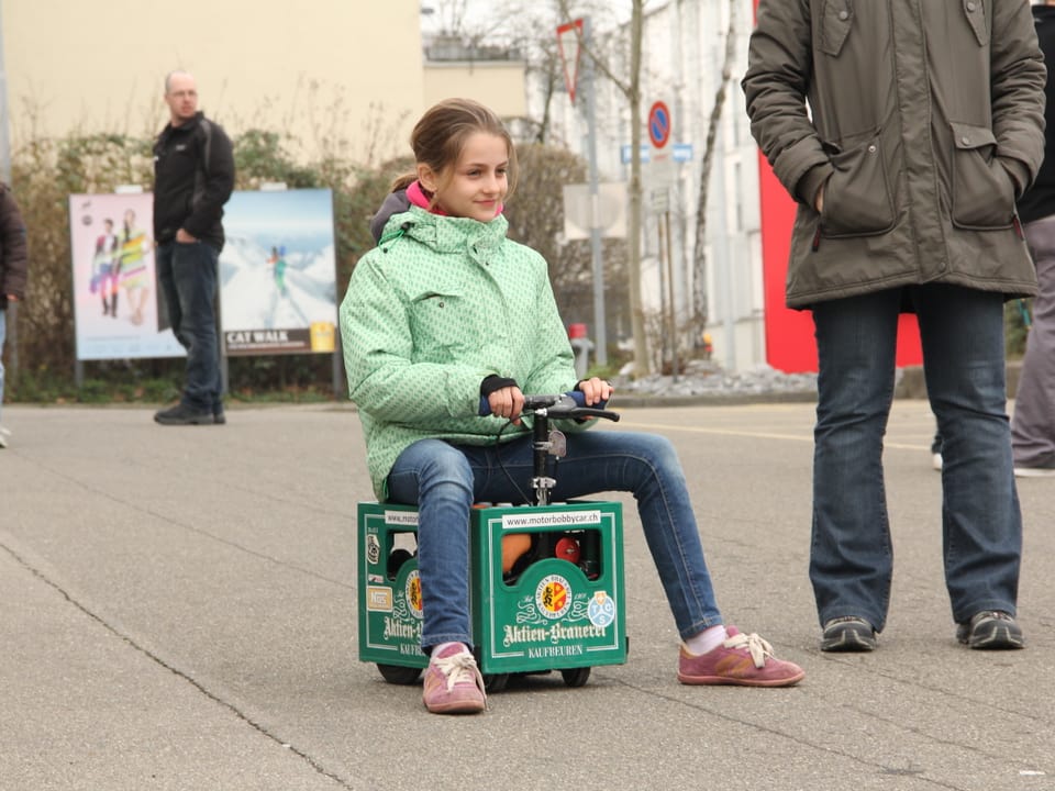 Mädchen auf einer motorisierten Bierkiste.