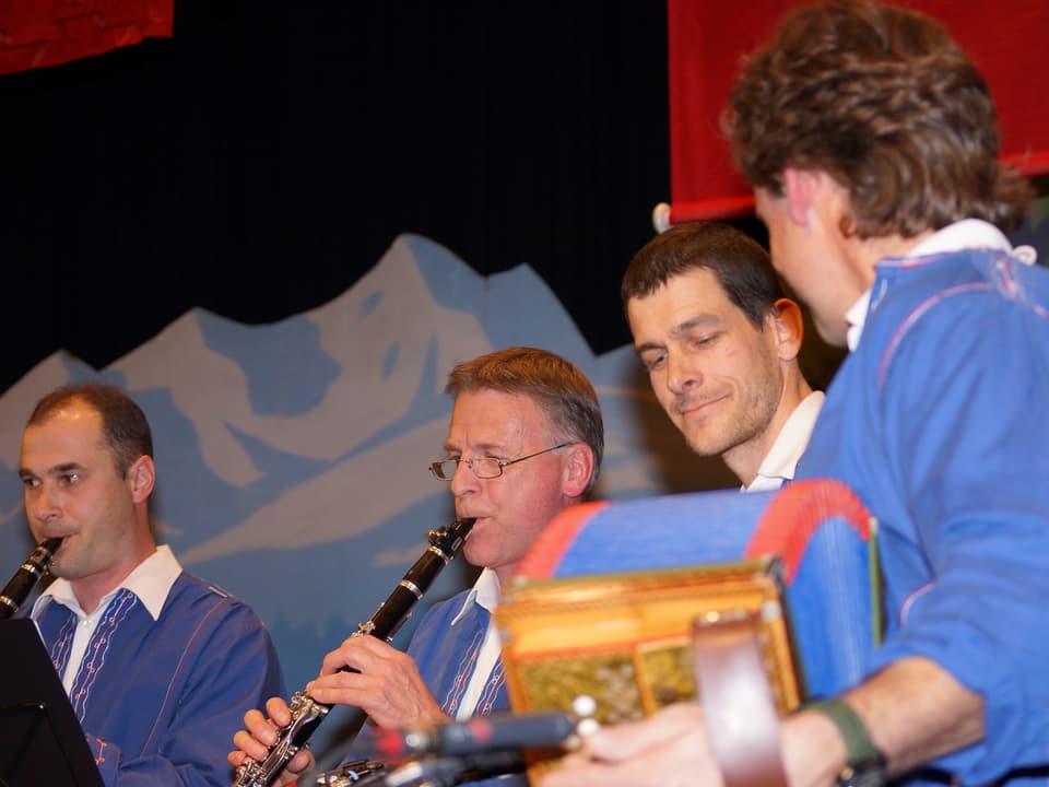 Vier Musikanten in blauen Sennenkutten während ihres Auftritts.