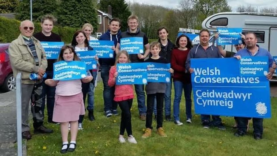 Frauen, Männer und Kinder tragen blaue Transparente mit der Aufschrift «Welsh Conservatives».