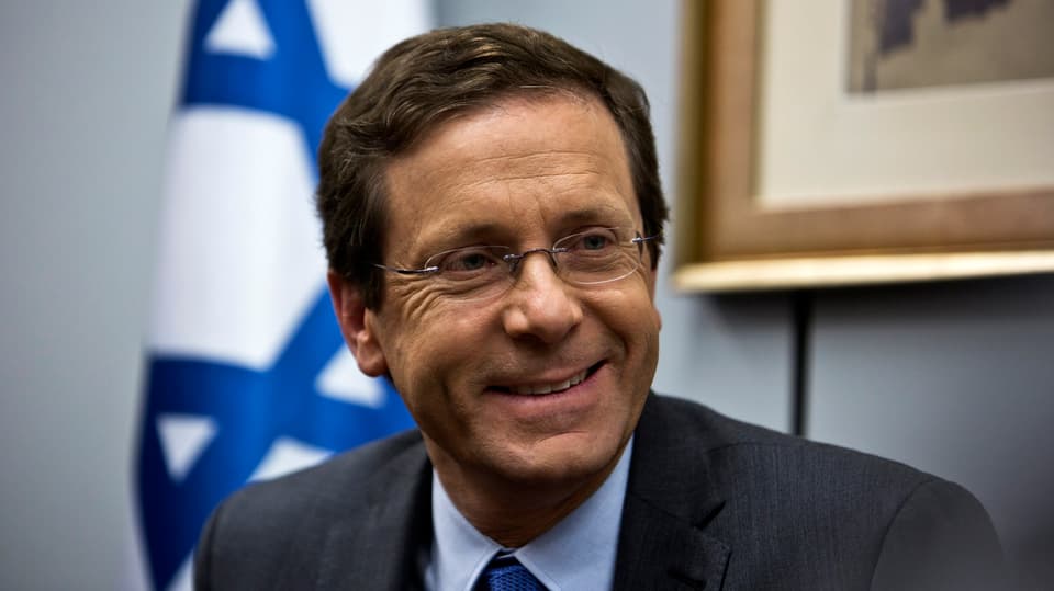 Porträt eines lächelnden Mannes, im Hintergrund die Flagge Israels