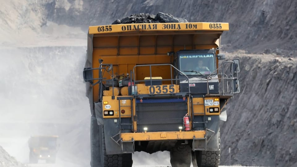 Ein gelbes Lastfahrzeug transportiert Kohle aus einem Abbaugebiet