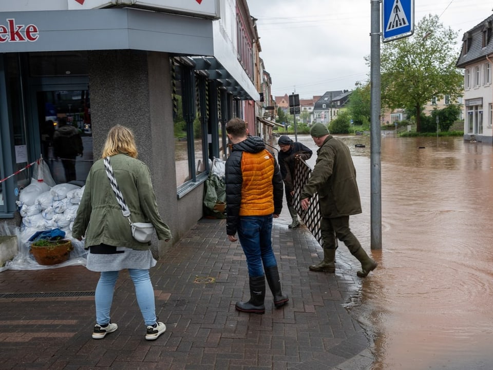 Menschen sichern ein Geschäft während einer Überschwemmung.