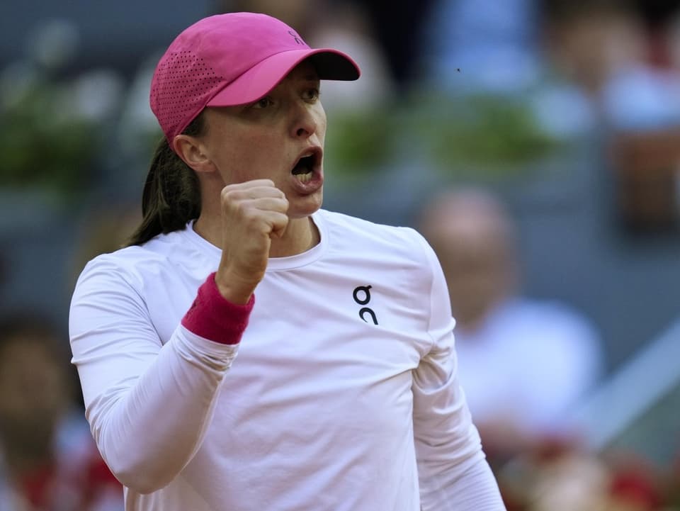 Tennisspielerin in weissem Outfit und rosa Kappe ballt die Faust im Erfolgsmoment.