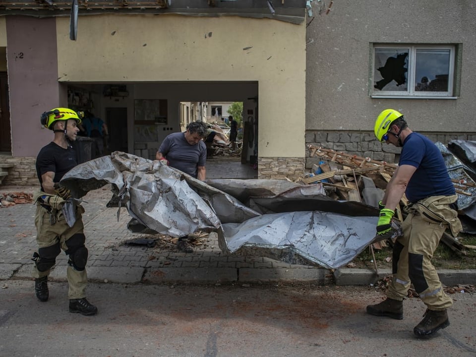 Einsatzkräfte der Feuerwehr räumen Trümmer weg in Moravská Nová Ves.