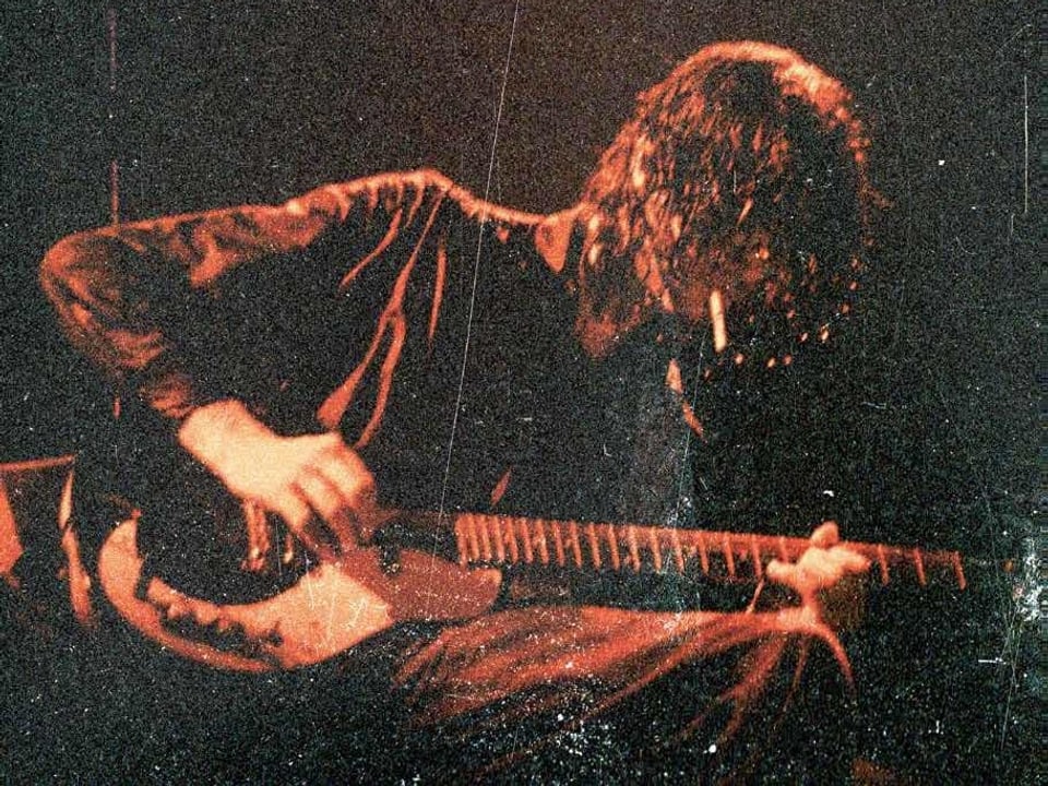 Jimmy Page von der Rockband Led Zeppelin mit Gitarre auf der Bühne.