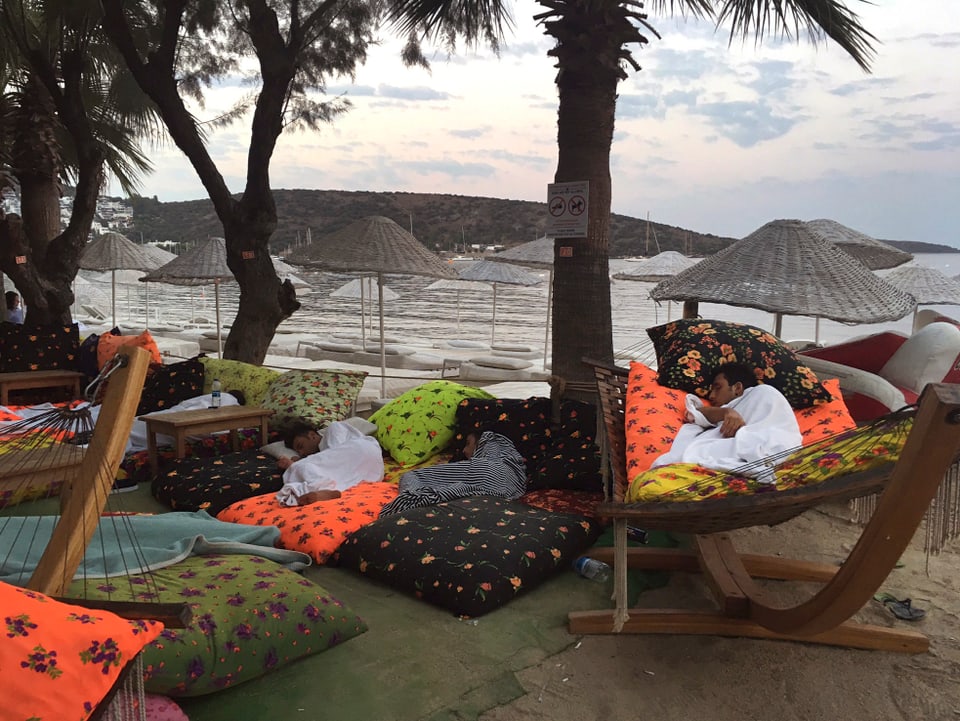 Menschen schlafen am Strand.