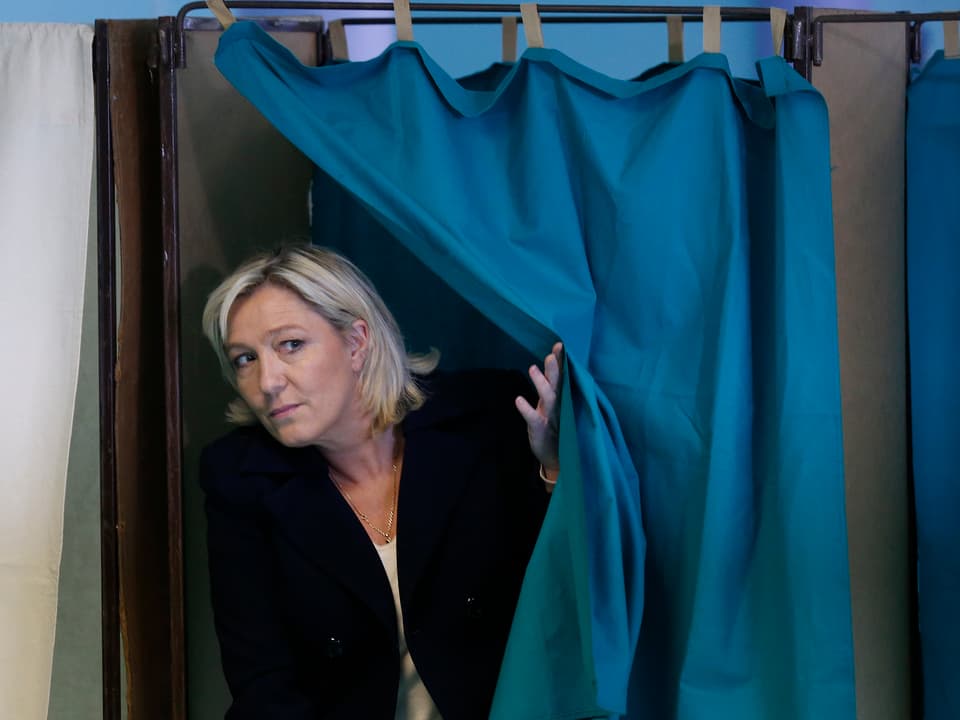 Marine Le Pen verlässt eine Wahlkabine.