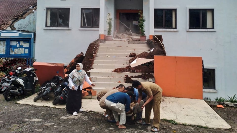 Beamte der Stadtverwaltung evakuieren ihren verletzten Kollegen nach einem Erdbeben in Cianjur