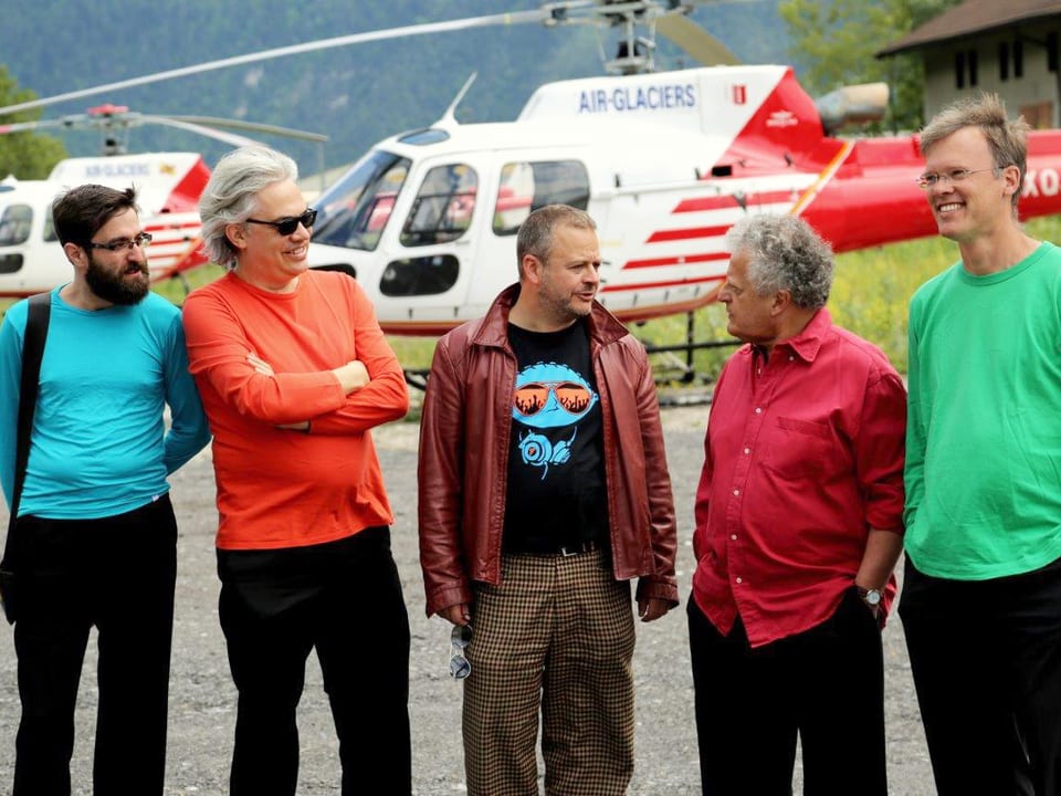 Fünf Männer stehen vor einem Helikopter.