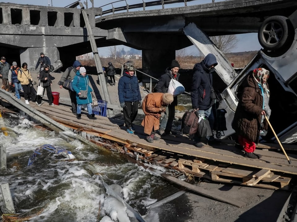 Flüchtende überqueren den Fluss Irpin ausserhalb von Kiew.