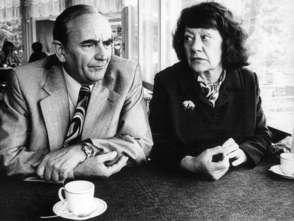 Die Schauspielerin Margrit Rainer und ihr Schauspieler-Kollege Ruedi Walter sitzen nebeneinander in einem Café.