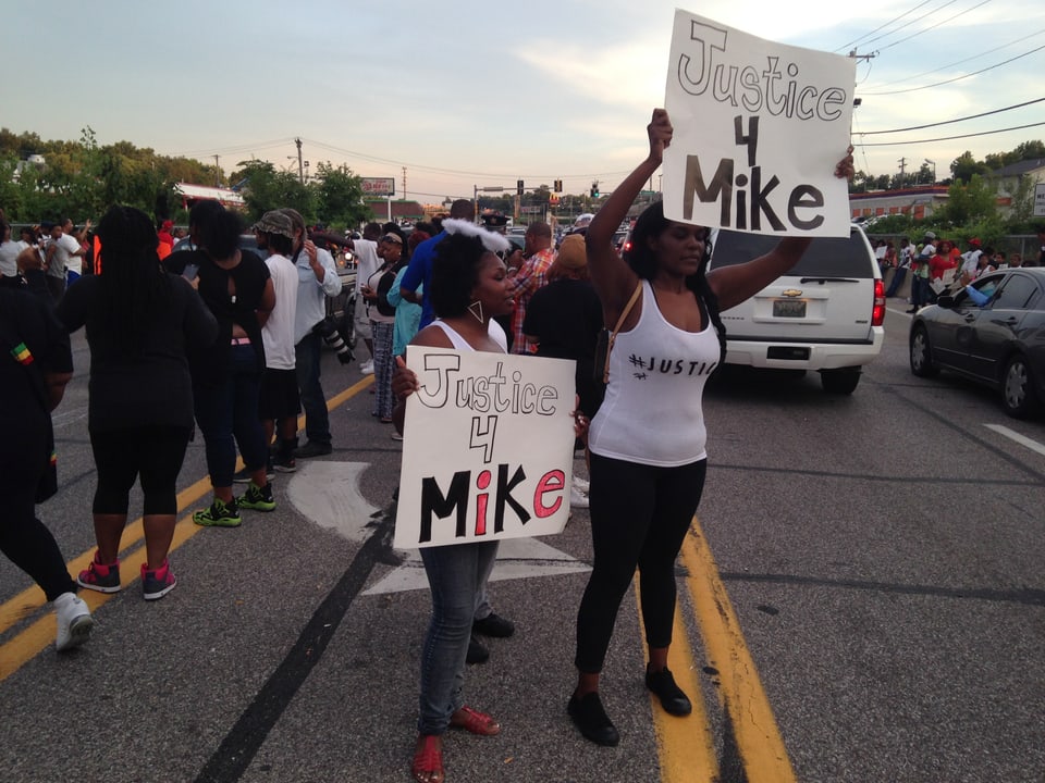 Zwei Frauen halten Plakate in die Höhe mit der Aufschrift «Justice for Mike» (Bild vom 15.08.14)