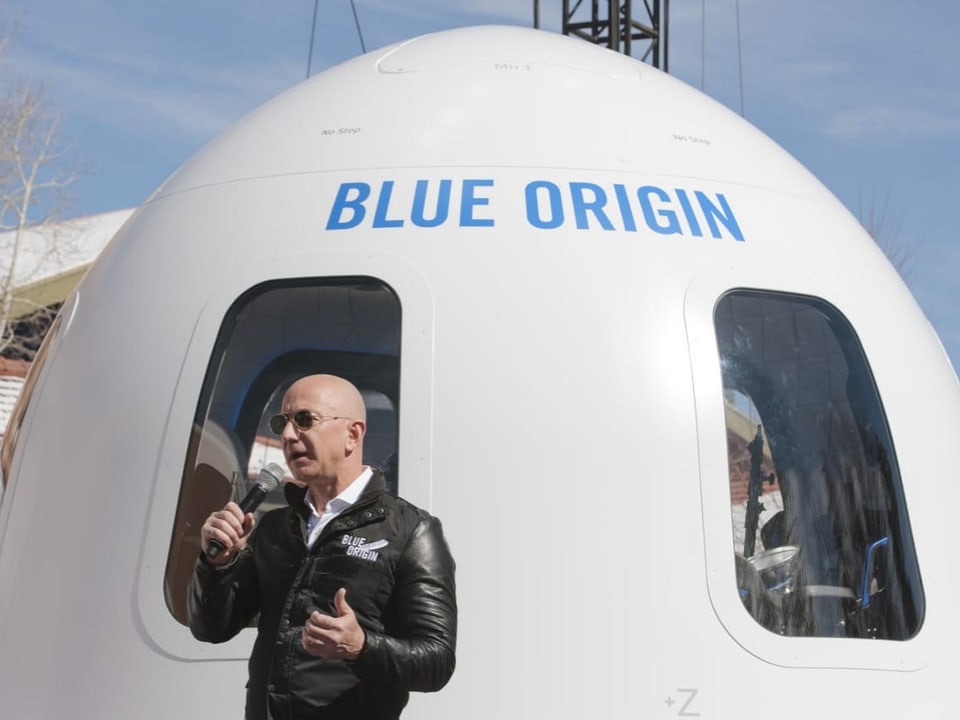 Jeff Bezos vor einer Rakete von Blue Origin