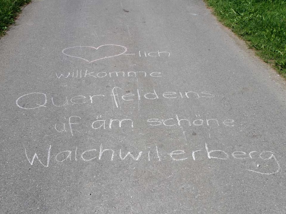 Auf der Strasse steht: Herzliche willkommen auf dem schönen Walchwilerberg.