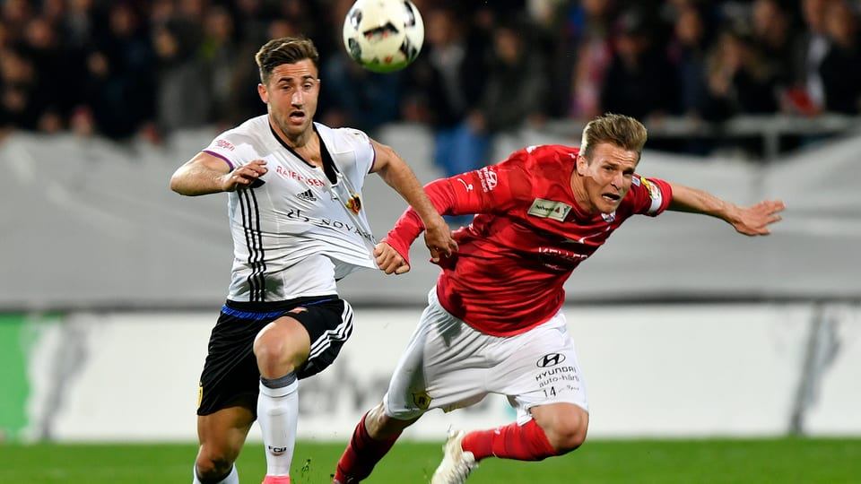 Ein Spieler des FC Winterthur reisst seinem Gegner vom FC Basel in vollem Lauf am Leibchen.