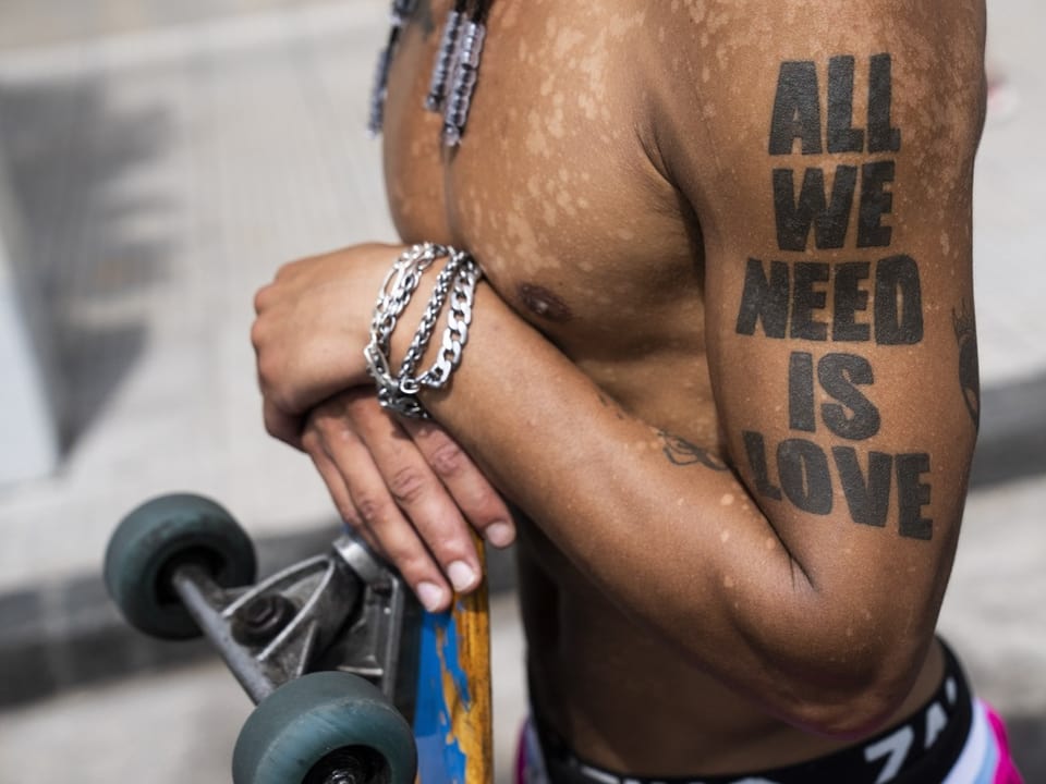Mann mit einem Tattoo: All we need is love.