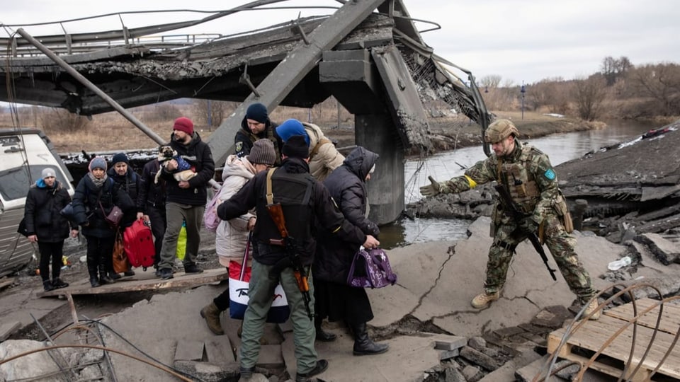 Ukrainer flüchten über eine zerstörte Autobahnbrücke in Irpin  (09.03.2022).