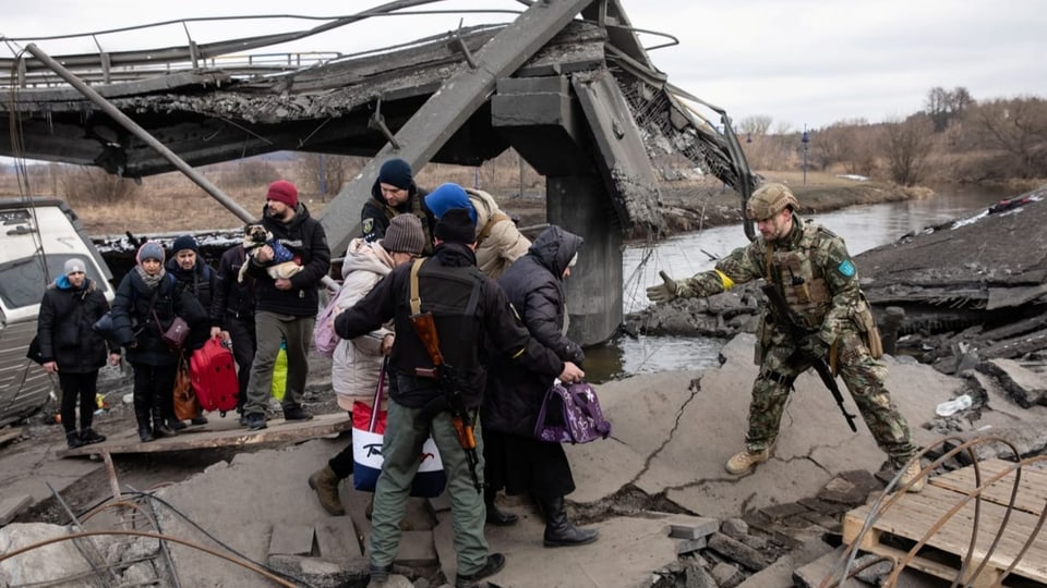 Ukrainer flüchten über eine zerstörte Autobahnbrücke in Irpin (09.03.2022).