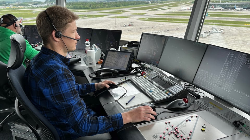 Flugverkehrsleiter Pascal Büsser vor Bildschirmen im Tower am Flughafen Zürich.