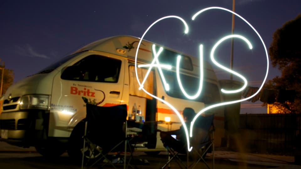 Nachtaufnahme Bus, daneben mit Licht ein Herz und '*US' gezeichnet