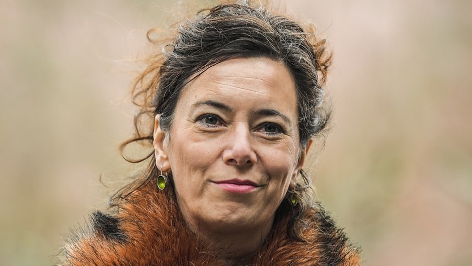 A woman with pin-up brown hair, earrings and a fur collar