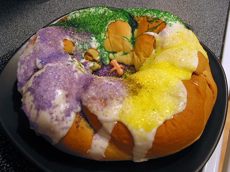 Ein runder Kuchen in den Farben violett, gelb und grün.